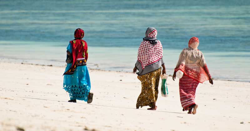 Women walking on the beautiful beach of Jambiani, Zanzibar, Tanzania