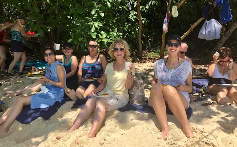 Margi enjoying lunch in the shade on a sandy Thailand beach