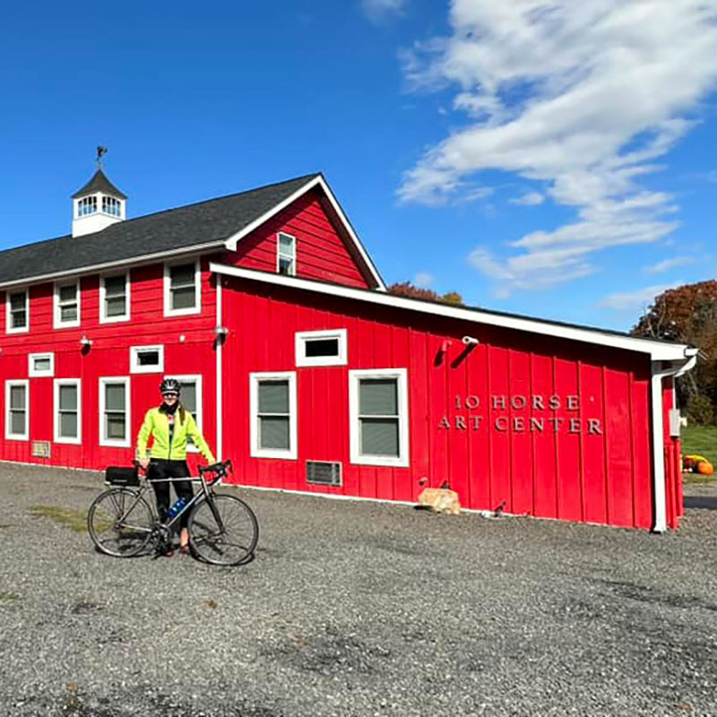 Margi stanfding with her bike outside the 10 Horse Art Center