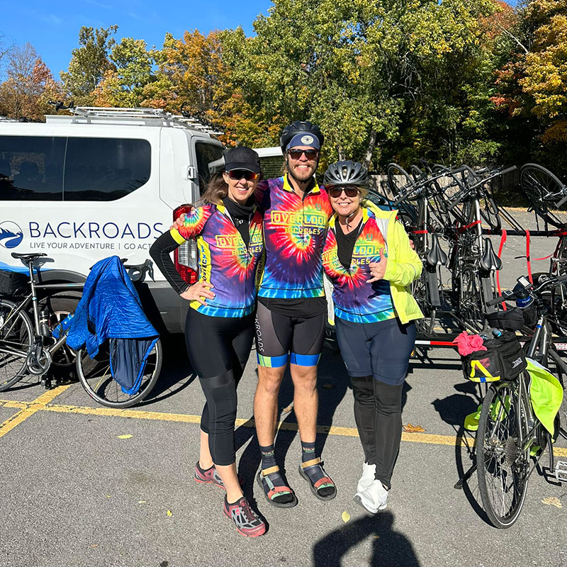 Three cyclists wearing tie-dye shirts purchased in Woodstock, NY.